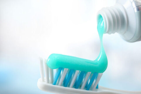 a toothpaste being poured onto a toothbrush