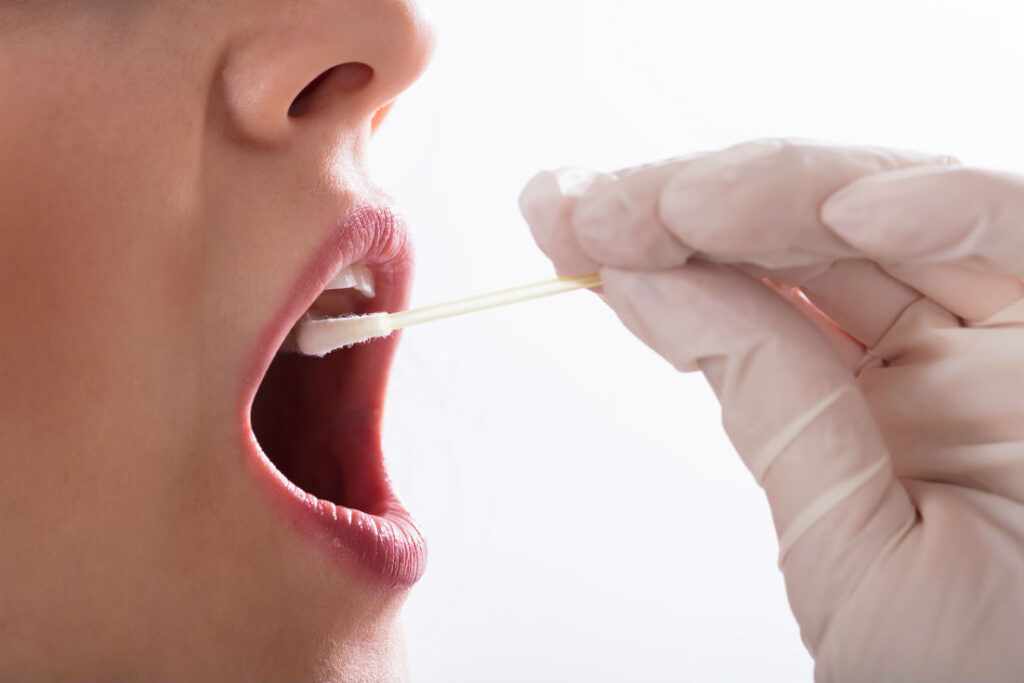 a person with a swab in their mouth
