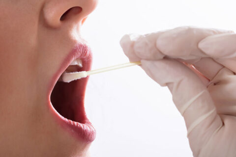 a person with a swab in their mouth