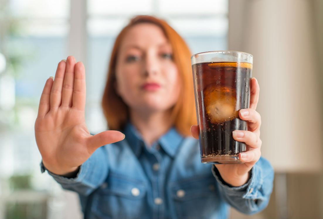 a person holding a glass of liquid 