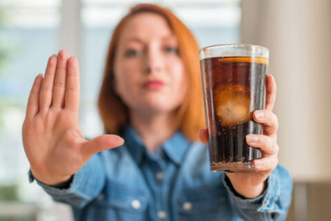 a person holding a glass of liquid